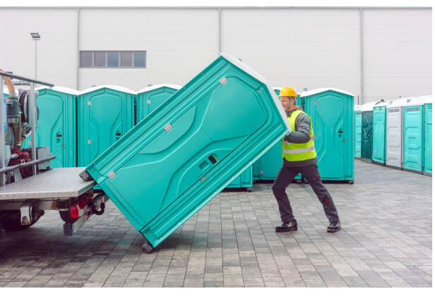 Crew member loading a portable restroom unit onto a delivery trailer at the El Cajon yard