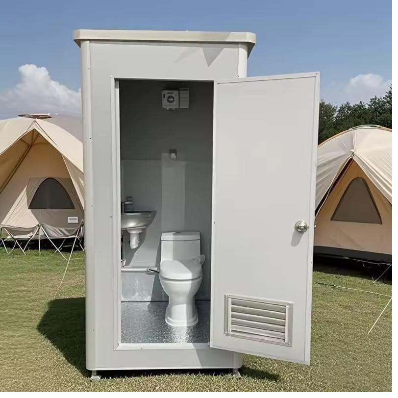 Portable restrooms lit by string lights at an evening wedding reception